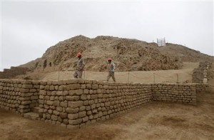Two workers walk on the coastal pyramid site called El Castillo de Huarmey in Huarmey